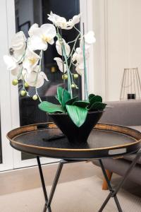 um vaso preto com flores brancas sobre uma mesa em Stunning 2BR Apt Bromley Views Terrace em Bromley