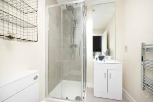 a white bathroom with a shower and a sink at Stunning 2BR Apt Bromley Views Terrace in Bromley