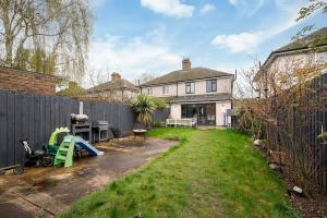 a backyard with a fence and a house at Charming 2BR House with Garden in Shepperton