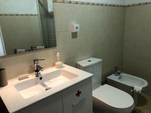 a bathroom with a sink and a toilet and a mirror at Apartamento 1 Penedo in Sintra +24 photos