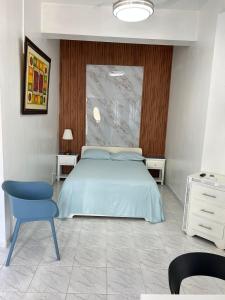 - une chambre avec un lit bleu et une chaise bleue dans l'établissement YOUR SPACE COLONIAL, à Saint-Domingue