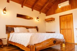ein Schlafzimmer mit einem Holzbett mit einem hölzernen Hundekopf in der Unterkunft La Fortuna Natural Green in Fortuna