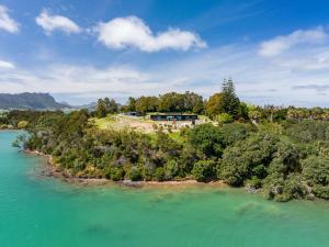 una vista aerea di una casa su un'isola in acqua di Nook Bay House a Whangarei