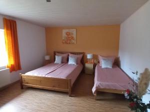 1 Schlafzimmer mit 2 Betten und rosa Bettwäsche in der Unterkunft Holiday home in Saint Quirin with garden in Saint-Quirin