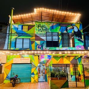 a building with a colorful facade with a motorcycle parked in front at Hostal Pura Vida la 70 in Medellín