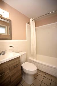 a bathroom with a toilet and a sink and a tub at Budget Inn Cicero in Cicero