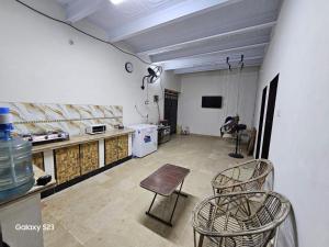 uma cozinha com uma mesa e duas cadeiras num quarto em SYED Rest House em Karachi