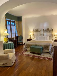 a large bedroom with a bed and a chair at Parador Santa Maria La Real in Sucre