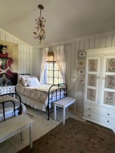 1 dormitorio con cama, ventana y lámpara de araña en Capilla-Casa de campo en Capilla del Señor