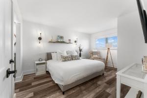 a white bedroom with a white bed and a window at The Summit 808 - Luxury Beach Resort Condo - Beachfront - Incredible Views - BEACH CHAIRS AND SUNSHADE Provided In Condo in Panama City Beach