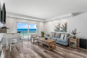 a living room with a blue couch and a piano at The Summit 808 - Luxury Beach Resort Condo - Beachfront - Incredible Views - BEACH CHAIRS AND SUNSHADE Provided In Condo in Panama City Beach