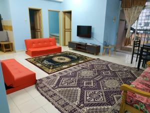 a living room with a couch and a tv at Budget Homestay Mantin Villa with 3 rooms and big swimming pool in Mantin