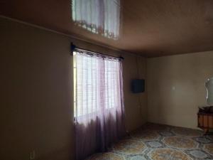 een lege kamer met een raam met een gordijn bij Casa 28 Millas in Madre de Dios