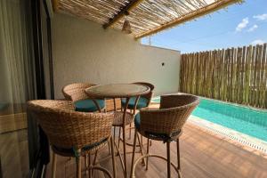 a patio with a table and chairs and a swimming pool at Casa Beverly Hills Pysá 02 Milagres Nobile Stays in São Miguel dos Milagres