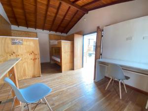 uma sala de aula com duas cadeiras, uma secretária e uma cama em ApartaLoft Carolina em Carolina del Principe