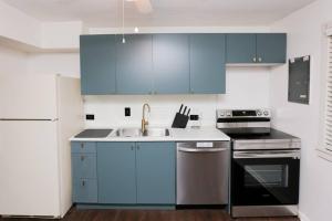 una cocina con armarios azules y fregadero en Tranquil Ranch Near Detroit & AA - Whole house with 2 bedrooms - Sleeps 6, en Westland