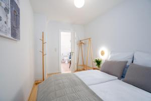 een witte slaapkamer met een bed en een raam bij AMW18 Ferienwohnung Alte Liebe in Häven