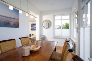 een eetkamer met een houten tafel en stoelen bij AMW18 Ferienwohnung Alte Liebe in Häven