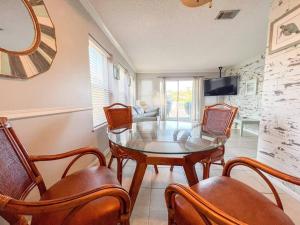 Un comedor con una mesa de cristal y sillas. en Anchors Aweigh!, en Destin
