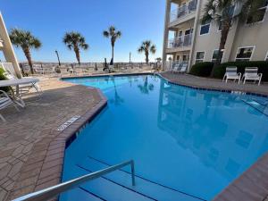 uma grande piscina azul em frente a um edifício em Anchors Aweigh! em Destin