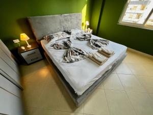 een bed in een kamer met een groene muur bij Guacamole 592 in Durrës