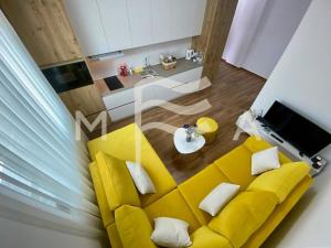 uma sala de estar com um sofá amarelo e uma mesa em Sunny Moon 510 em Durrës