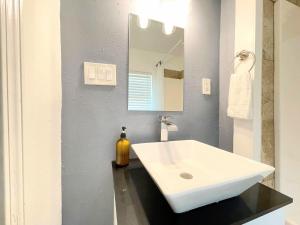 a bathroom with a white sink and a mirror at Mangosteen in New Orleans