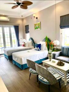 une chambre d'hôtel avec deux lits et un canapé dans l'établissement Vườn Vua Resort & Sun Villas Khu Thanh Liên, à Ðồng Phú