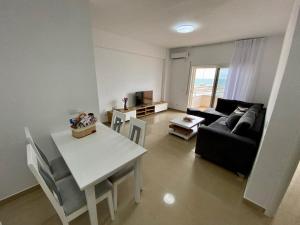 ein Wohnzimmer mit einem Sofa und einem Tisch in der Unterkunft Costante 614 in Durrës
