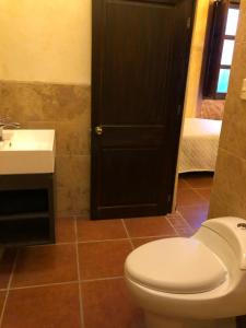 a bathroom with a white toilet and a sink at Casa Familiar San Sebastian in Antigua Guatemala