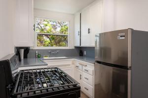 a kitchen with a stove and a refrigerator at A Slice of Paradise: 2BR Apt. with Hot Tub in Los Angeles