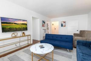 洛杉矶Charming 1-bedroom Apartment with Hot Tub的客厅配有蓝色的沙发和桌子