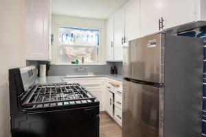 a kitchen with a stove and a stainless steel refrigerator at Prime Location and Luxury Living w/ Hot Tub in Los Angeles