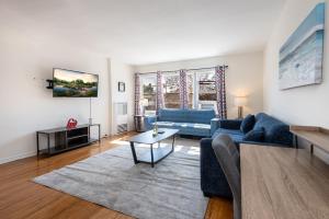 ein Wohnzimmer mit 2 blauen Sofas und einem Tisch in der Unterkunft Modern Charming 1BR-Apartment with Hot Tub in Los Angeles