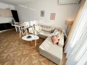 uma sala de estar com um sofá branco e uma mesa em Harmony 591 em Durrës