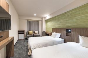 Postel nebo postele na pokoji v ubytování Hotel JAL City Nagano