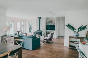 a living room with a blue couch and a fireplace at Verandah Retreat - A Beach House by the sea in Cowes