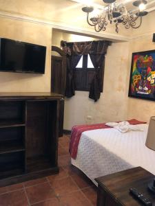 a bedroom with a bed and a flat screen tv at Casa Familiar San Sebastian in Antigua Guatemala