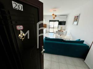 Eine schwarze Tür führt in ein Wohnzimmer mit einem blauen Sofa. in der Unterkunft Nouveau 623 in Durrës