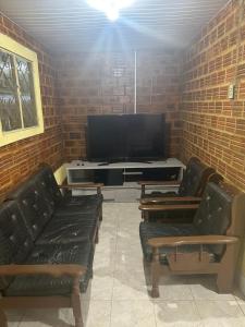 uma sala de estar com 2 sofás e uma televisão de ecrã plano em Chácara com uma área de lazer top em Caruaru
