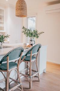 a kitchen with a table with green chairs at Verandah Retreat - A Beach House by the sea in Cowes