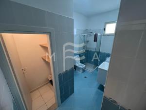 y baño con ducha, aseo y espejo. en Oceanfront Oasis 770, en Durrës