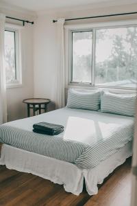 a bed in a bedroom with a window at Verandah Retreat - A Beach House by the sea in Cowes