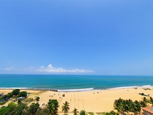 vistas a una playa con palmeras y al océano en Sea Wave Luxuy Apartment en Negombo