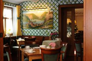 a dining room with tables and chairs and a painting on the wall at Gasthaus Weingut Stahl in Oberwesel