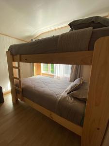 two bunk beds in a room with a window at Refugio Ballena Hostel in Castro