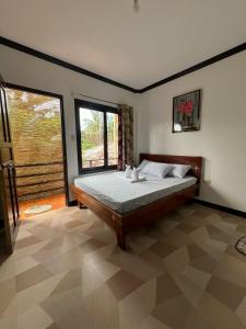 a bedroom with a bed and a large window at SHELVES SIARGAO in General Luna