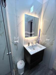 a bathroom with a sink and a toilet and a mirror at Delight 808 in Golem