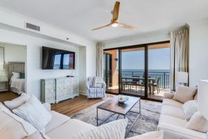 una sala de estar con muebles blancos y vistas al océano. en Gulf Front Condo Outdoor & Indoor Pools, en Orange Beach
