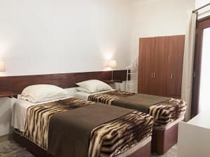 a hotel room with two beds and a cabinet at Apartamento 2 Penedo in Sintra